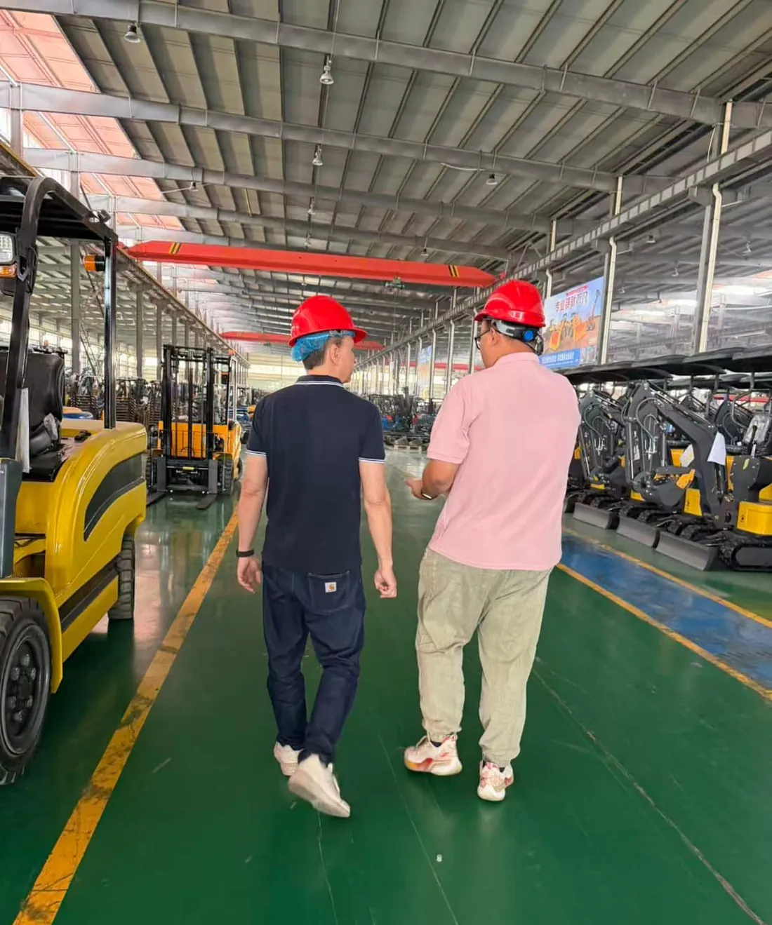 Dans les allées d'une usine auditée : chariots élévateurs et mini-pelles en fin de ligne.